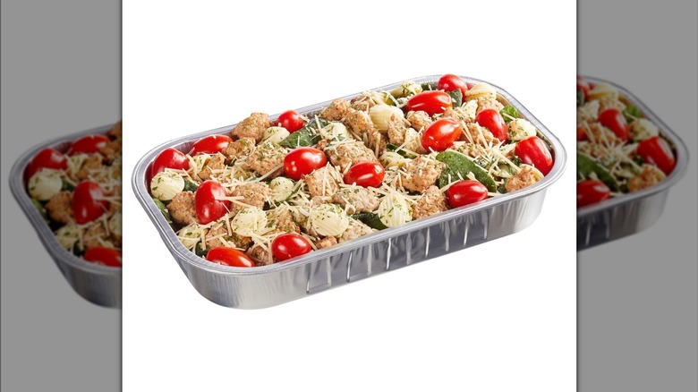 A silver foil tray of Kirkland Signature Italian Sausage & Pasta in Wine Sauce on display