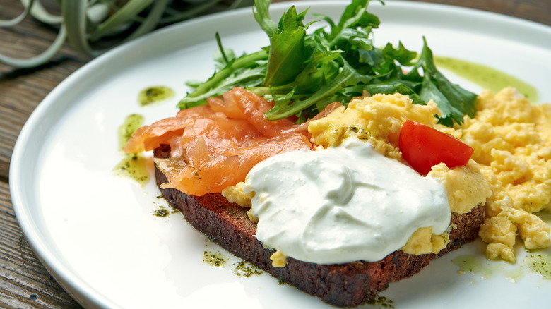 Greek yogurt on toast with scrambled eggs and smoked salmon