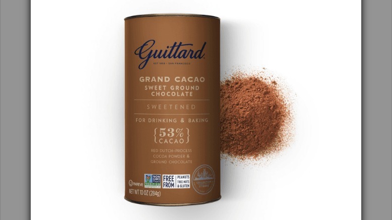 A can of Guittard Grand Cacao Sweet Ground Chocolate with a little powder sprinkled next to it