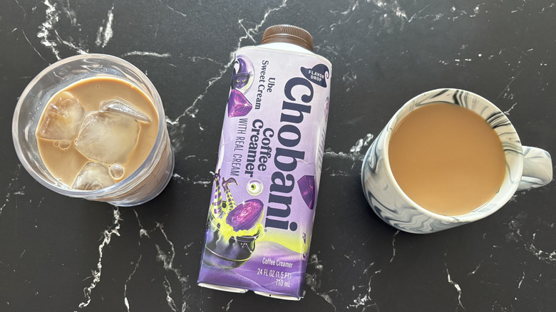 Chobani Ube Sweet Cream coffee creamer bottle in between cup of iced coffee and hot coffee
