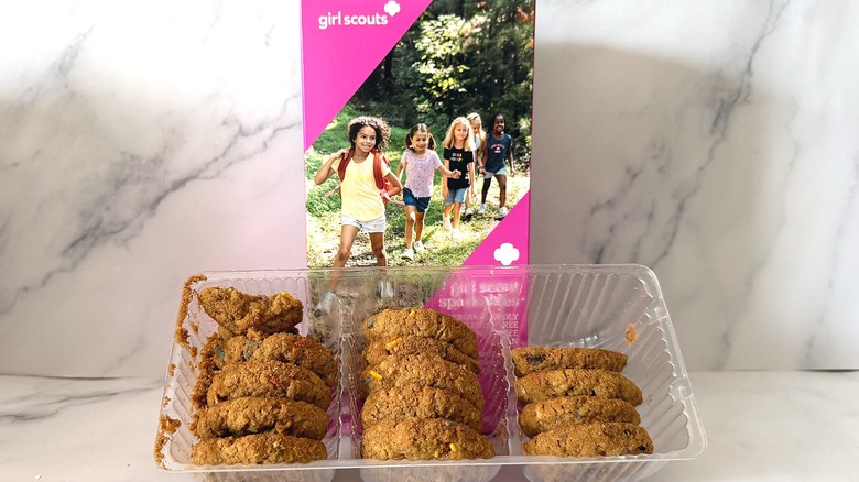 Sparkables Girl Scout Cookies in plastic packaging leaning against cookie box on marble surface