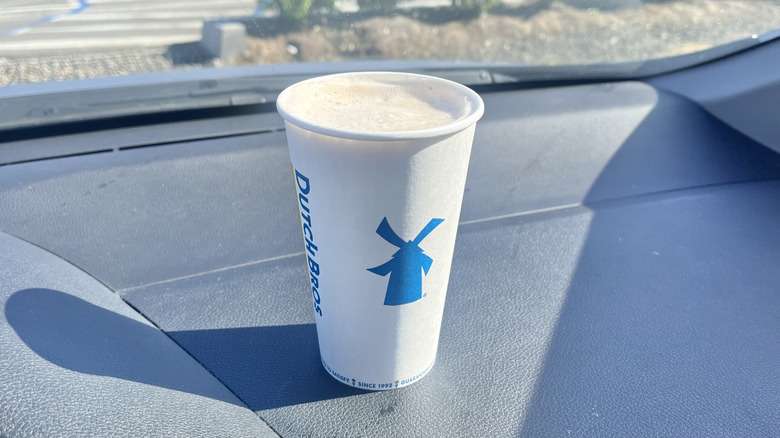 Dutch Bros Banana Split Hot Latte in a car served in a paper cup