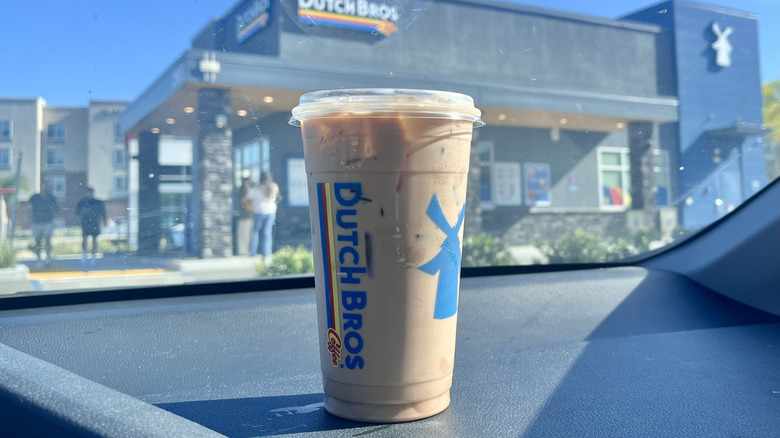 Dutch Bros Banana Bread Iced Mocha served in a plastic cup with view of store