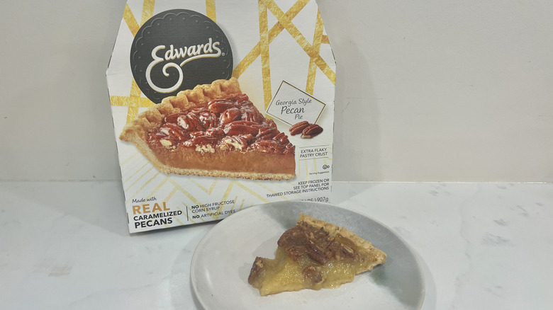 Edwards pecan pie slice on a plate in front of the package