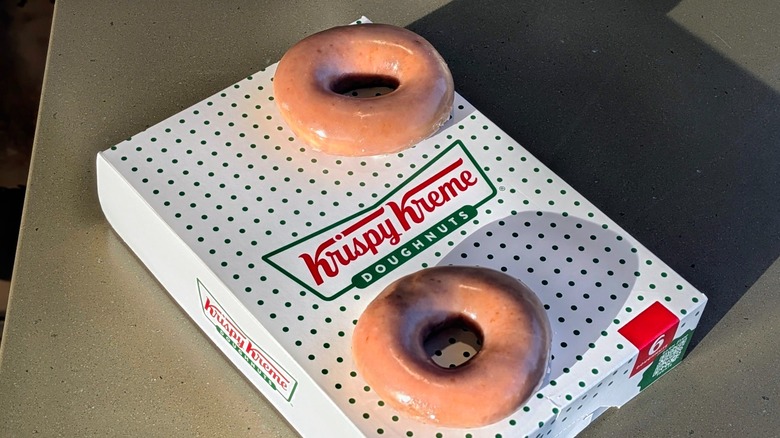 Two Apple Cider Original Glazed donuts on top of a Krispy Kreme box