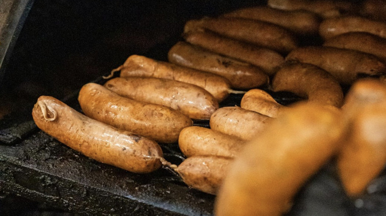 A close up of a bunch of sausages cooking on grill