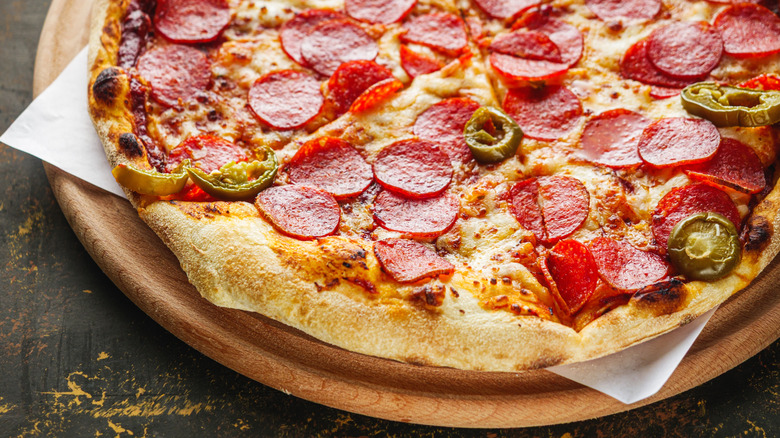 Close-up of a pizza topped with pepperoni and jalapeño peppers