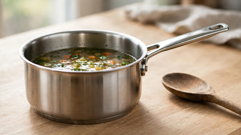 A hot saucepan sitting directly on top of a wooden countertop