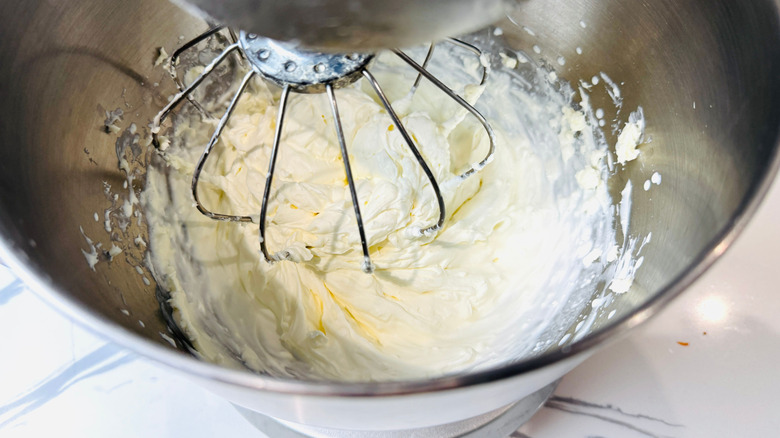Whipped cream in stand mixer bowl with whisk attachment
