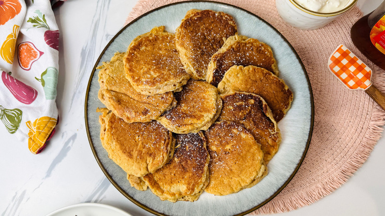 Carrot cake pancakes sprinkled with powdered sugar on plate