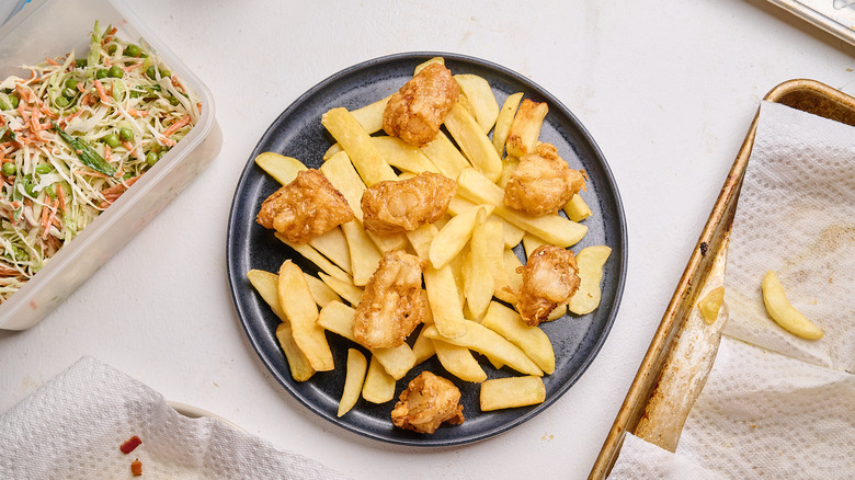 fries on a serving platter topped with fish