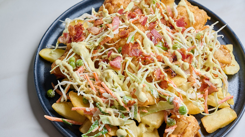 loaded fries on a plate topped with bacon and ranch