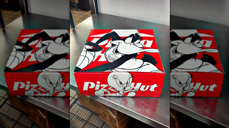 A Pizza Hut Space Jam Triple Treat Box sits on a counter in the restaurant's back room.
