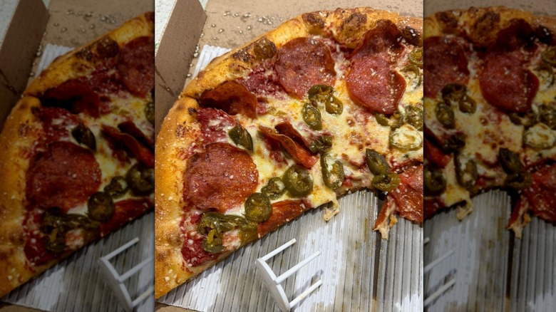 A Marco's New York Style Pizza in a box with some slices missing, topped the pepperoni and jalapenos