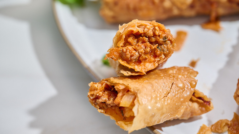 Inside of a halved egg roll pointed to camera