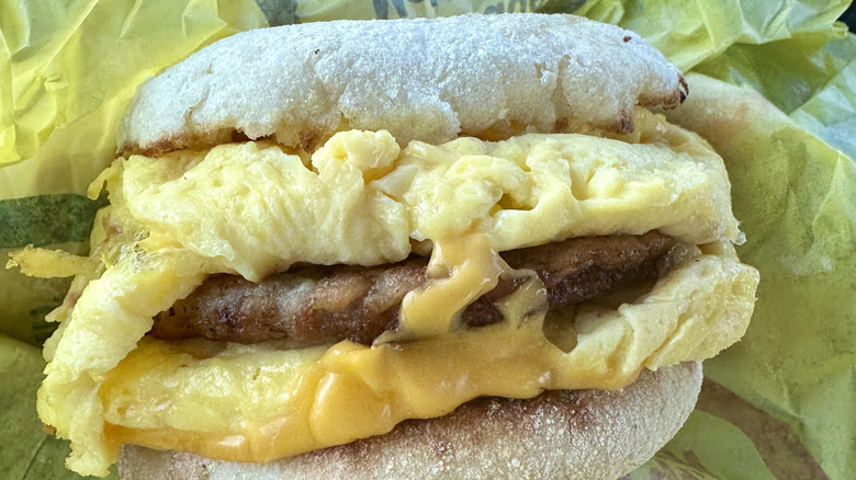 An muffing and sausage sandwich with scrambled eggs