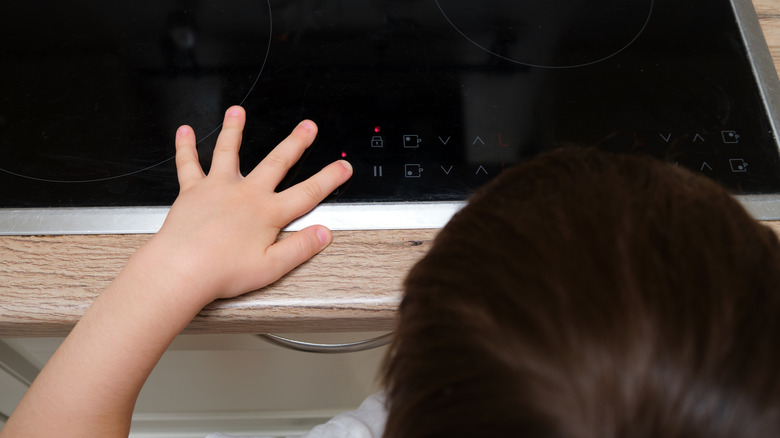 Kid turning an induction stovetop on