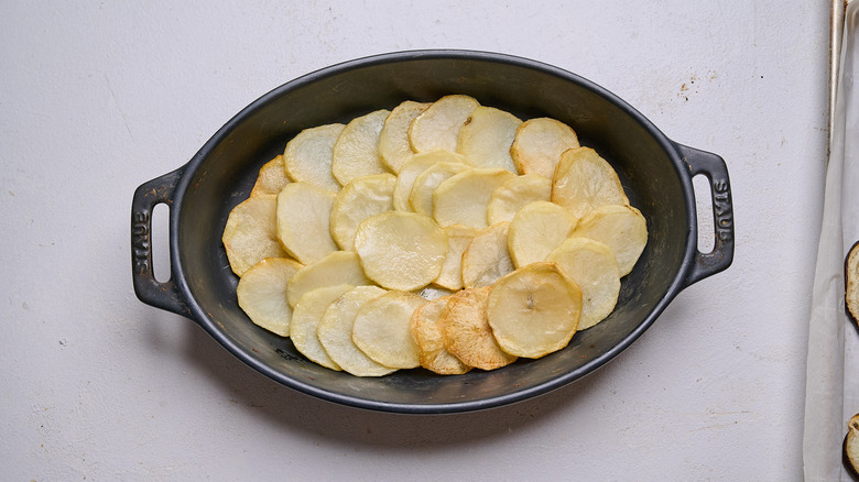 arranging potatoes into casserole dish