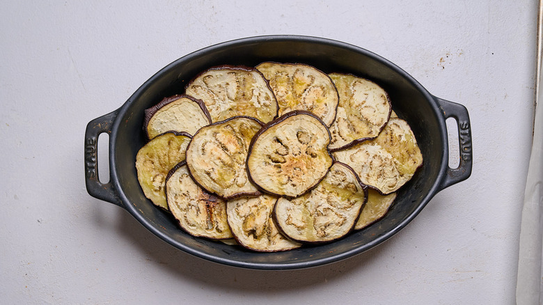 eggplant layered in casserole dish over potatoes