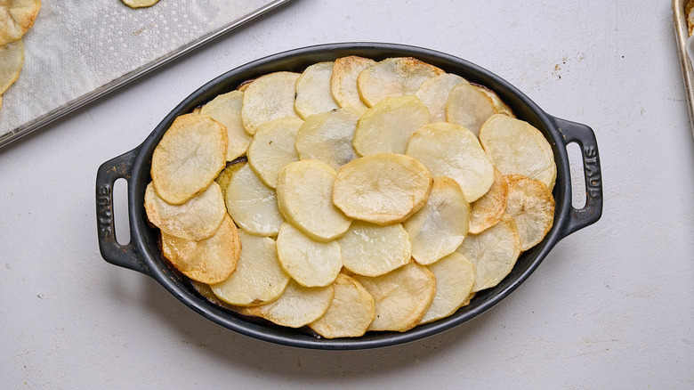 eggplant and potatoes layered into casserole dish