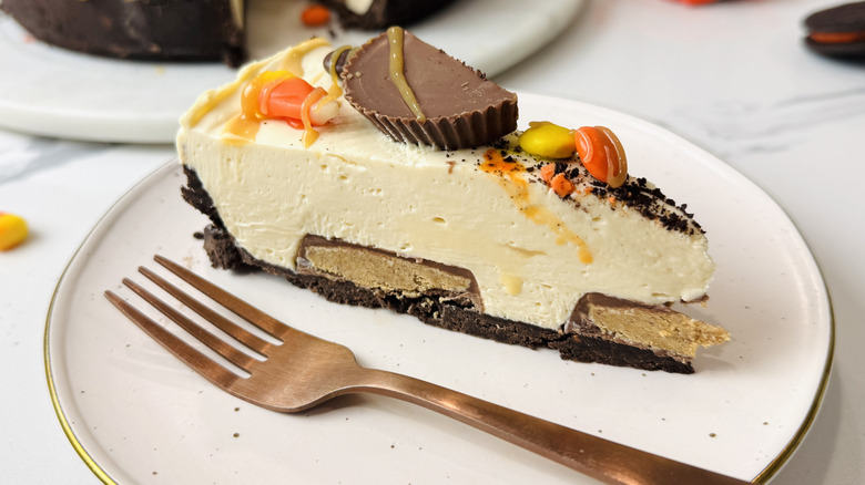 Slice of Halloween candy cheesecake on plate with fork