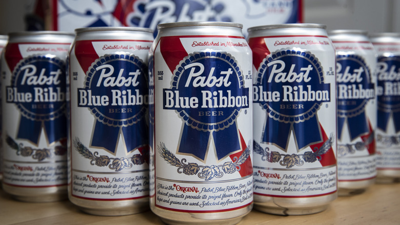 Cans of PBR displayed by a case on a table