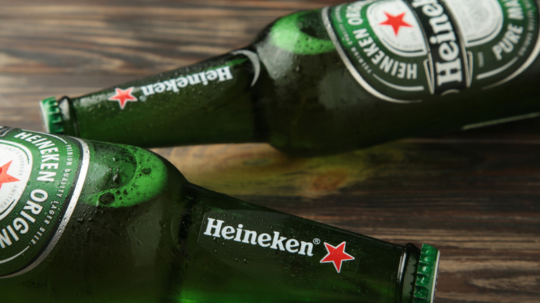 Green Heineken bottles on a table lying sideways