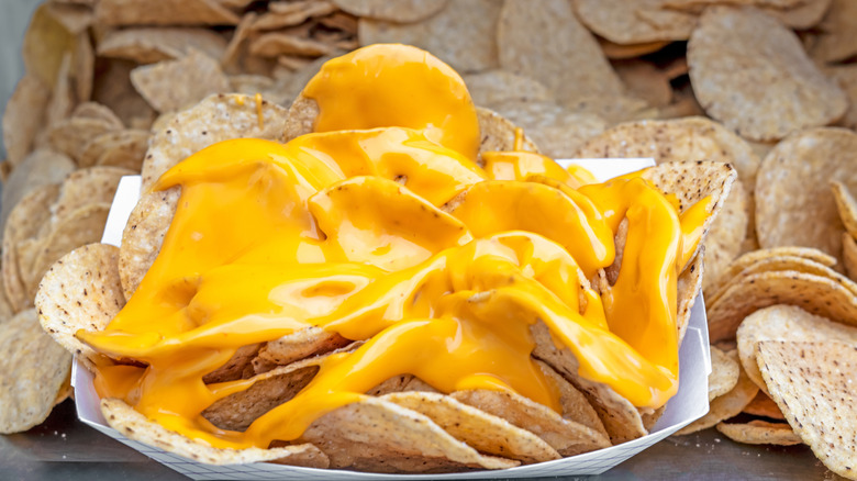 Tray of nachos with cheese surrounded with corn tortilla chips
