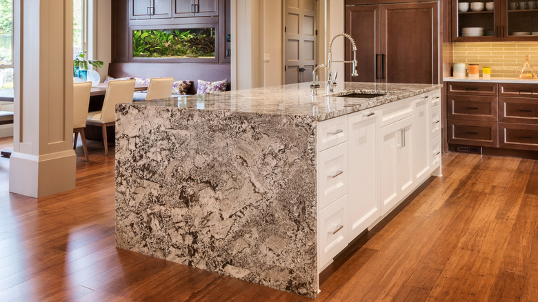 A waterfall edge marbled gray kitchen island