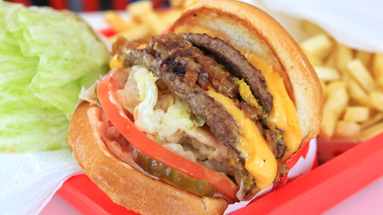 In-N-Out burger Animal Style with fries and lettuce on a tray.