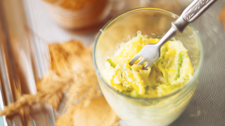 A microwave omelet in a glass mug with a fork sticking in.
