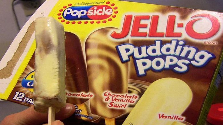 A package of Jell-O Pudding Pops with the actual pop held against it, in chocolate and vanilla swirl flavor