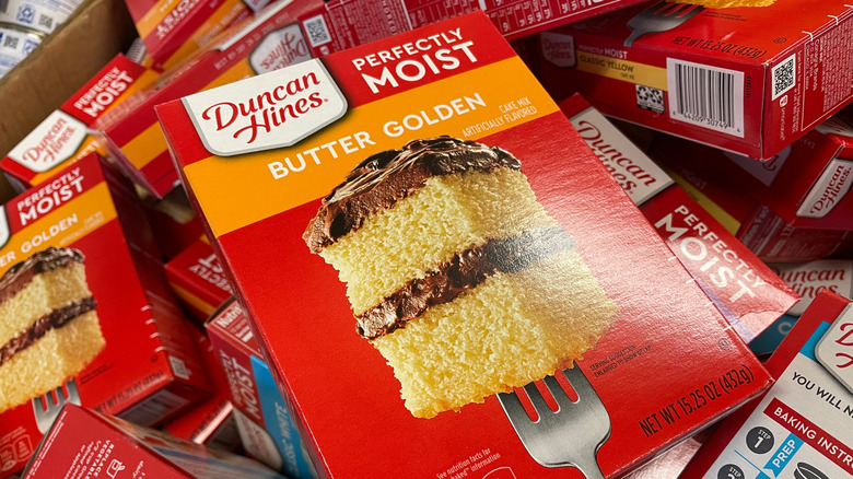 A box of Duncan Hines cake mixes in a grocery store with the Butter Golden Mix on top