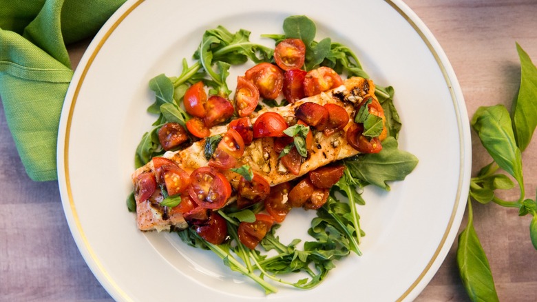 An overhead shot of bruschetta salmon on a white plate.