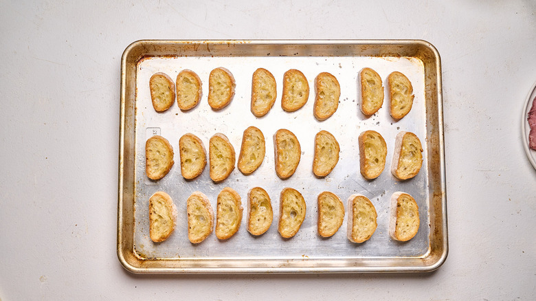 golden brown crostinis on a baking sheet