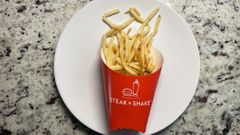 Steak n shake fries in a container and on a plate