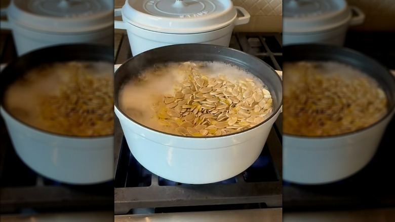 Pumpkin seeds boiling in pot of water on stovetop