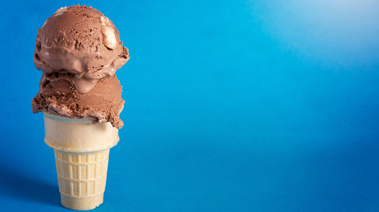 chocolate ice cream in cone on blue background