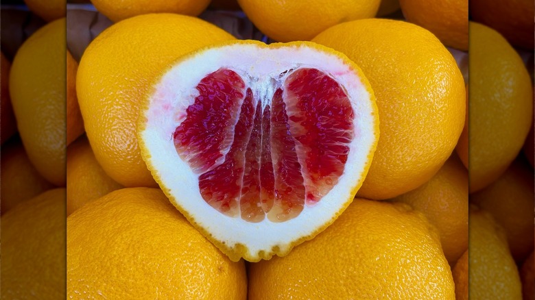 A Valentine Pummelo cut open on top of others