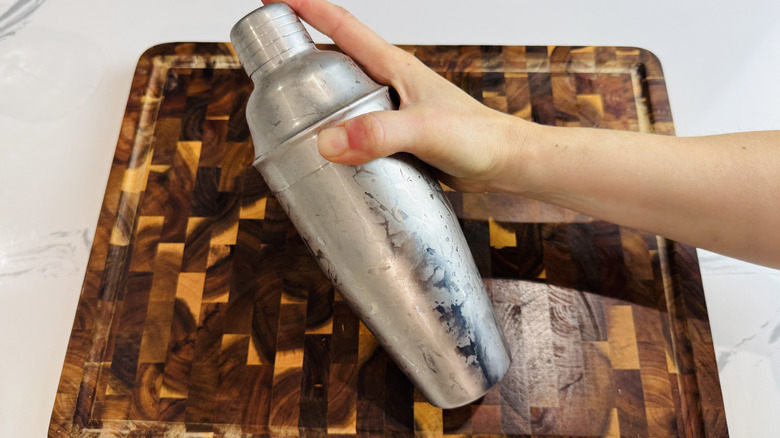 Hand holding frosty cocktail shaker