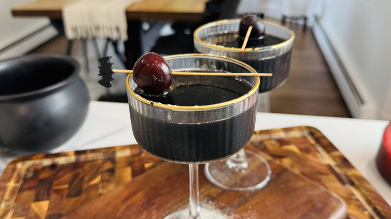 Black magic cocktails with cherry garnishes