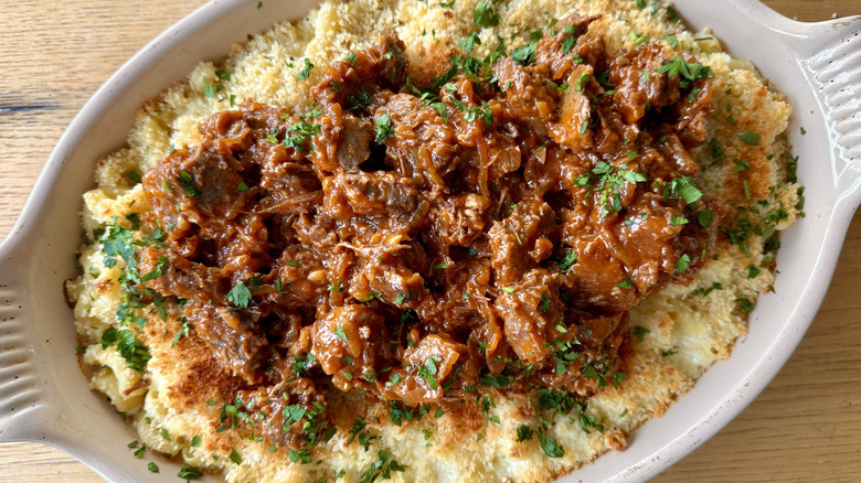 Top view of a mac and cheese with BBQ meat.