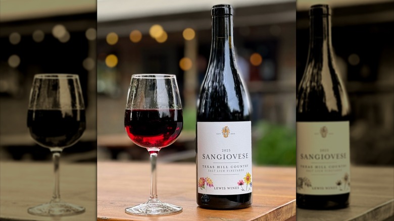 A bottle of Sangiovese with wine glass filled halfway with red wine