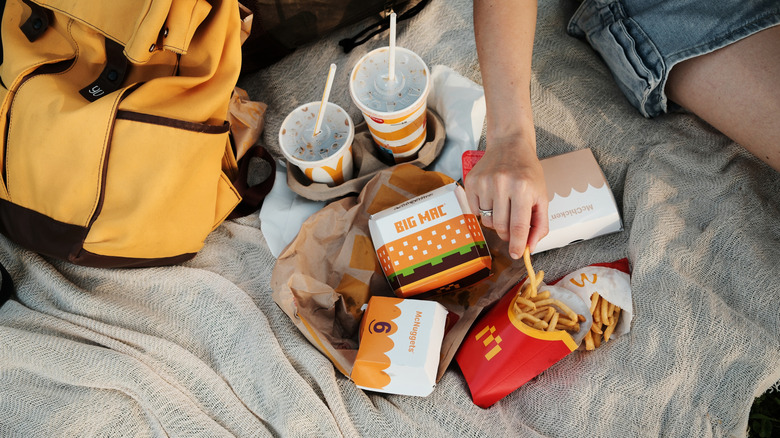 A bunch of McDonald's burger containers and drinks on a blanket