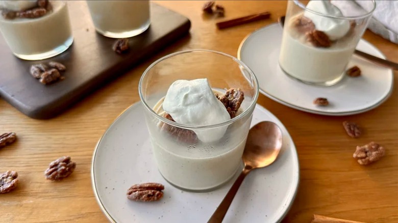 Vanilla chai spice pudding in a glass container on a plate with a copper spoon.
