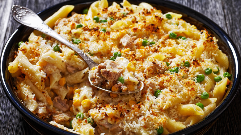 A large tuna casserole in a round plate with a spoon in it