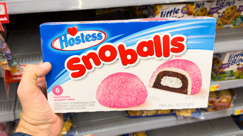 Hand holding box of Hostess Snoballs at store