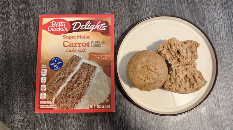 A box of Betty Crocker carrot cake mix next to the baked muffins on a plate.