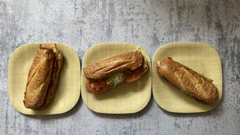 Three cheesesteaks on three separate plates