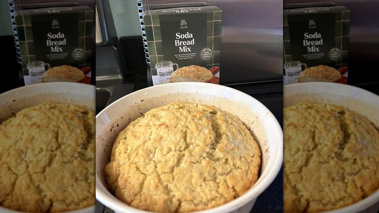 A box of Aldi Soda Bread Mix next to a white bowl containing baked bread